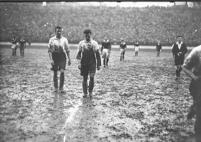 27th February 1937:  Two Preston North End players leave the pitch at half-time covered in mud, during a match against Charlton Athletic at The Valley.  (Photo by J. A. Hampton/Topical Press Agency/Getty Images)
