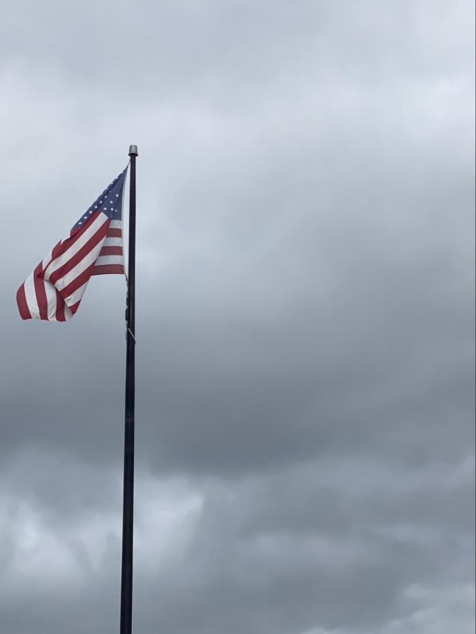 The flag flies under cloudy skies outside DHS.
