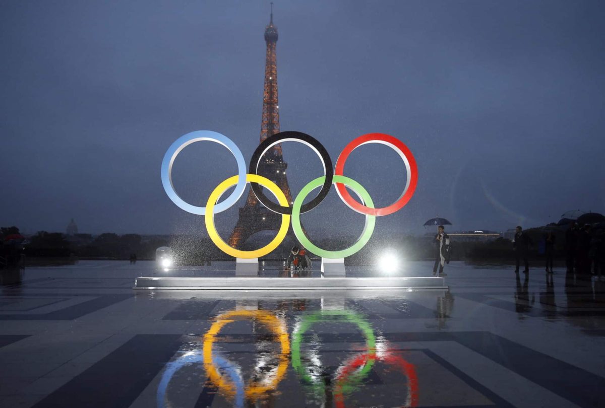 The Olympic rings shine in front of the Eiffel Tower in Paris, France.